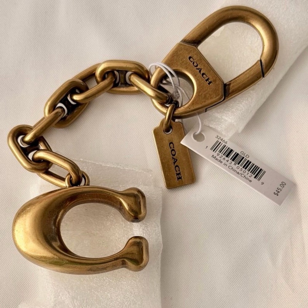 NWT Vintage Coach Signature bag charm in a gold-tone metal finish.